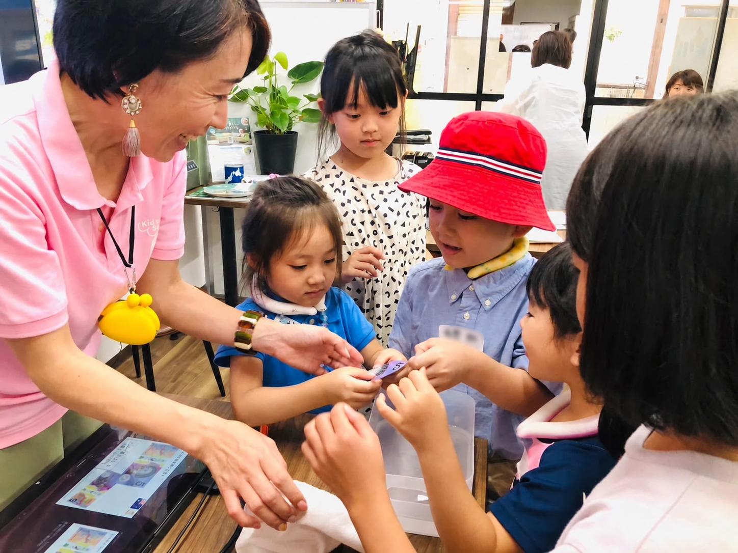 子どもたちと外国のお金を手に取りながら学ぶ土居由紀子